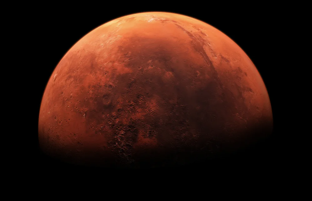 A partial view of the red planet, Mars, in the darkness of space